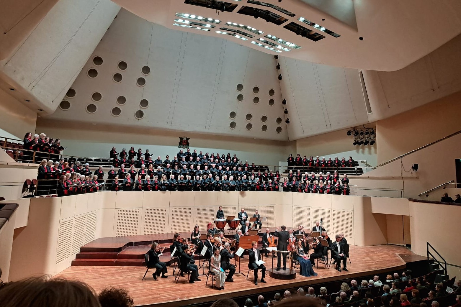 Historical photograph of the choir singing with an orchestra at a concert in The Royal Concert Hall, Nottingham.
